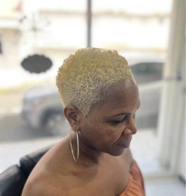 Coupe courte blonde bouclée vue de face réalisée chez Ciseaux d'Or